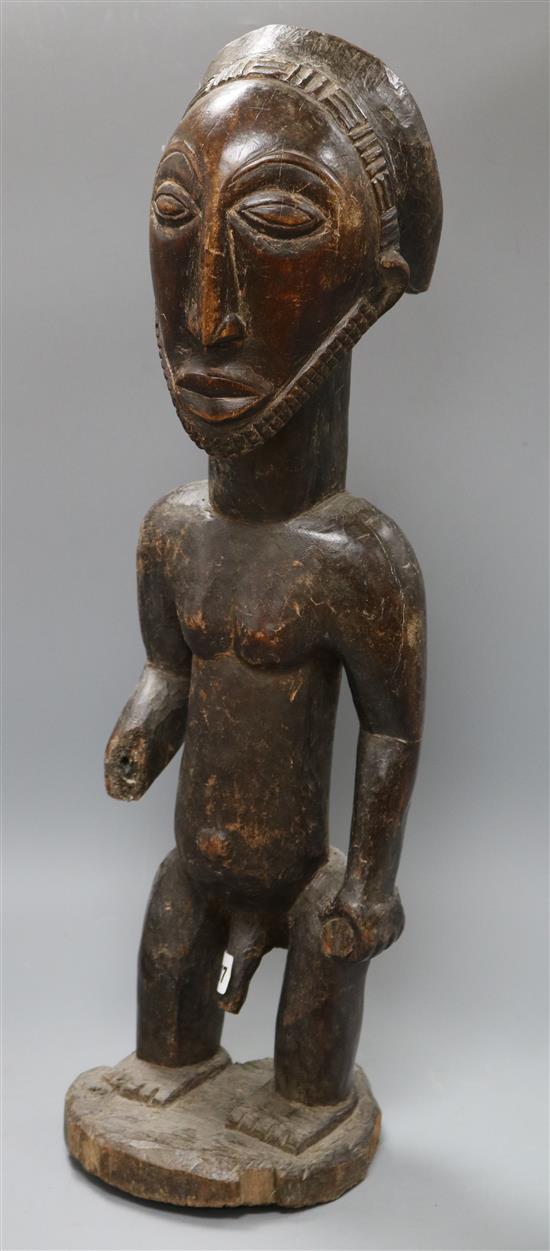 A West African carved wood figure of a standing man height 64cm